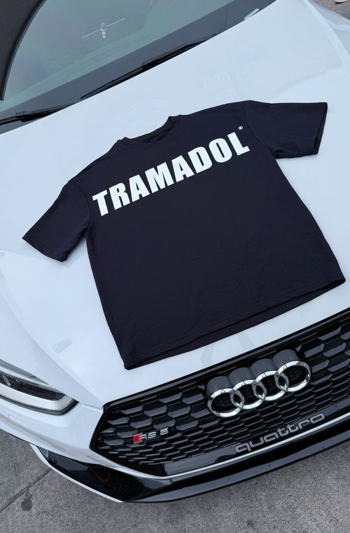 Black TRAMADOL® t-shirt displayed on a white Audi.